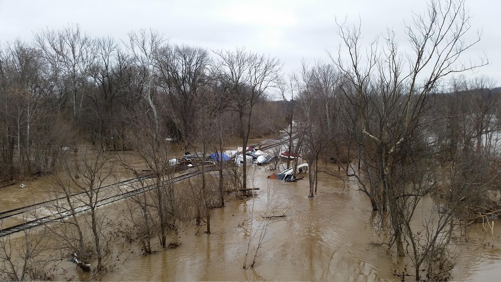 Flooded roadway with standing water along a curb